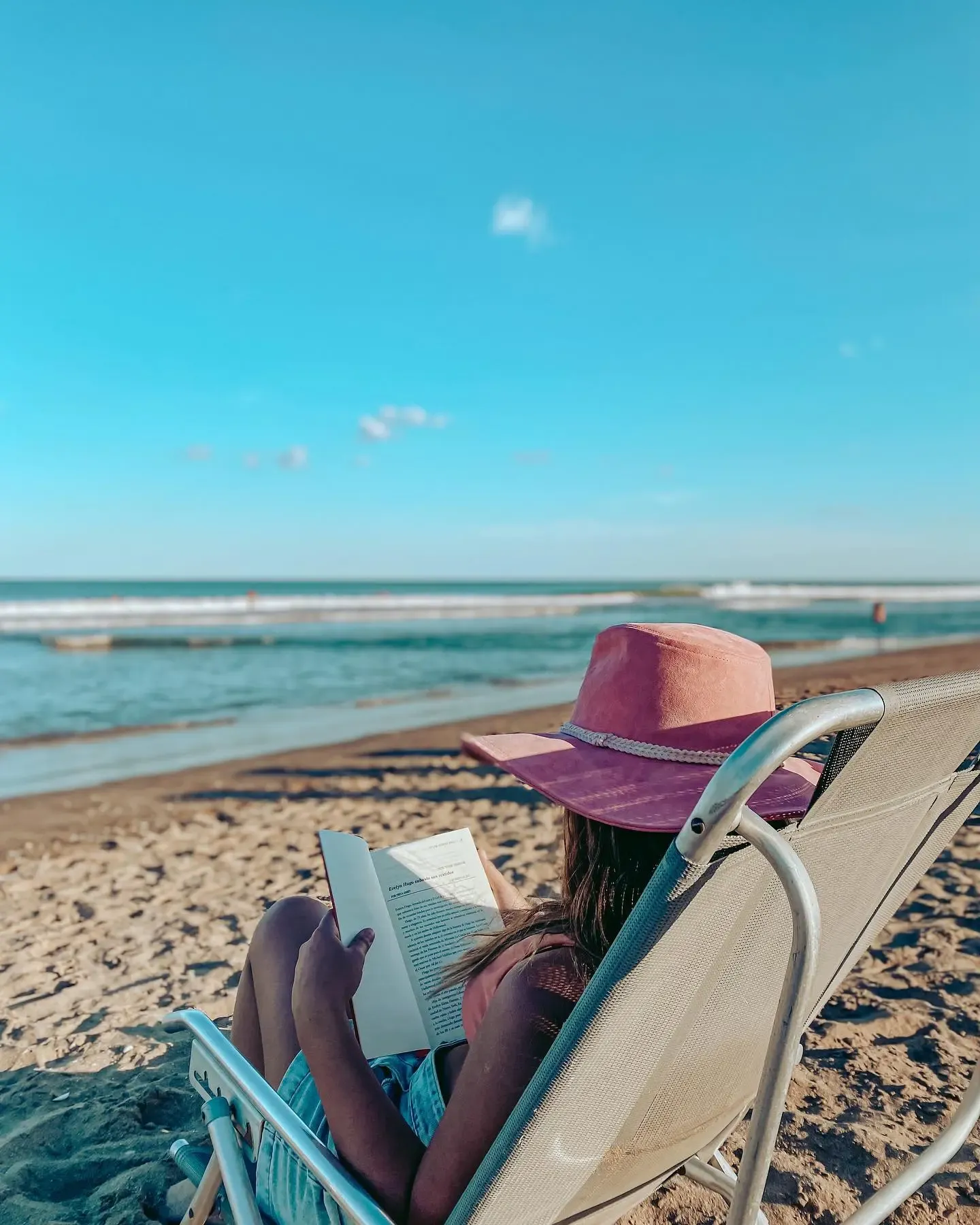 imagen leyendo un libro en la playa